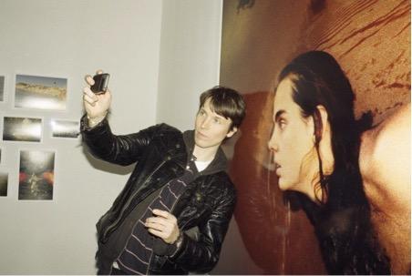 A person taking a photo next to art.