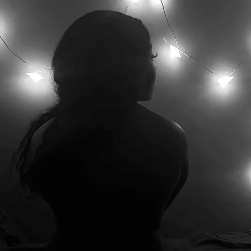 A girl in the dark with star lights.