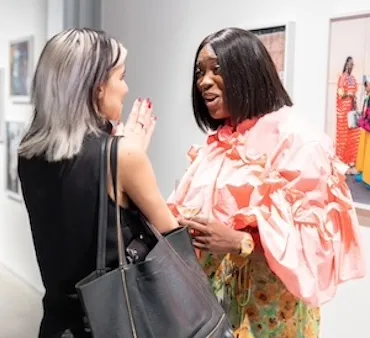 two women laughing in exhibition