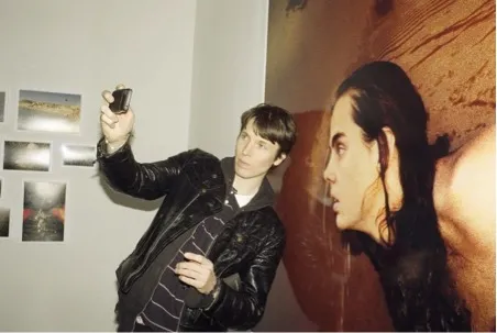 A person taking a photo next to art.